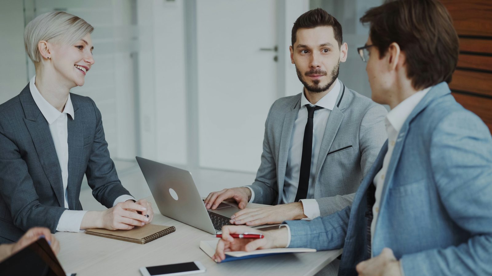 Business professionals meeting around a laptop
