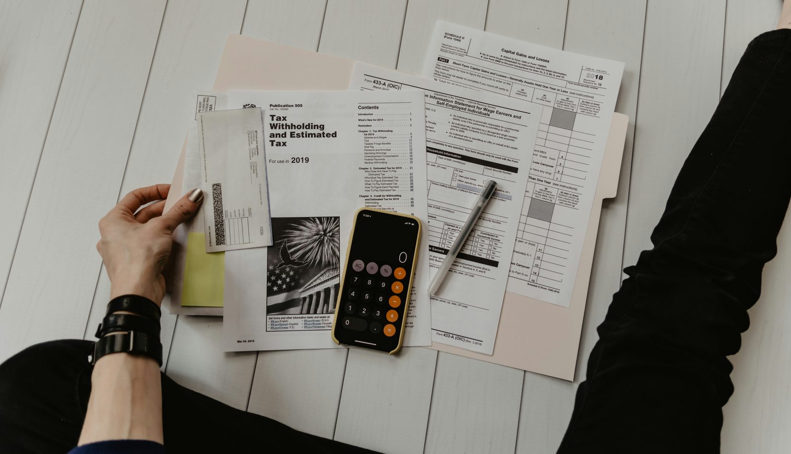 Tax documents with calculator and pen for personal income tax